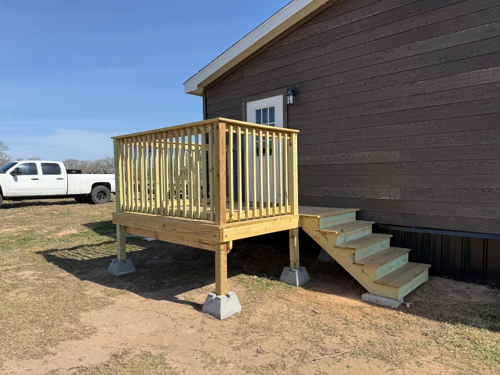 Compact wood deck with railing and side stairs