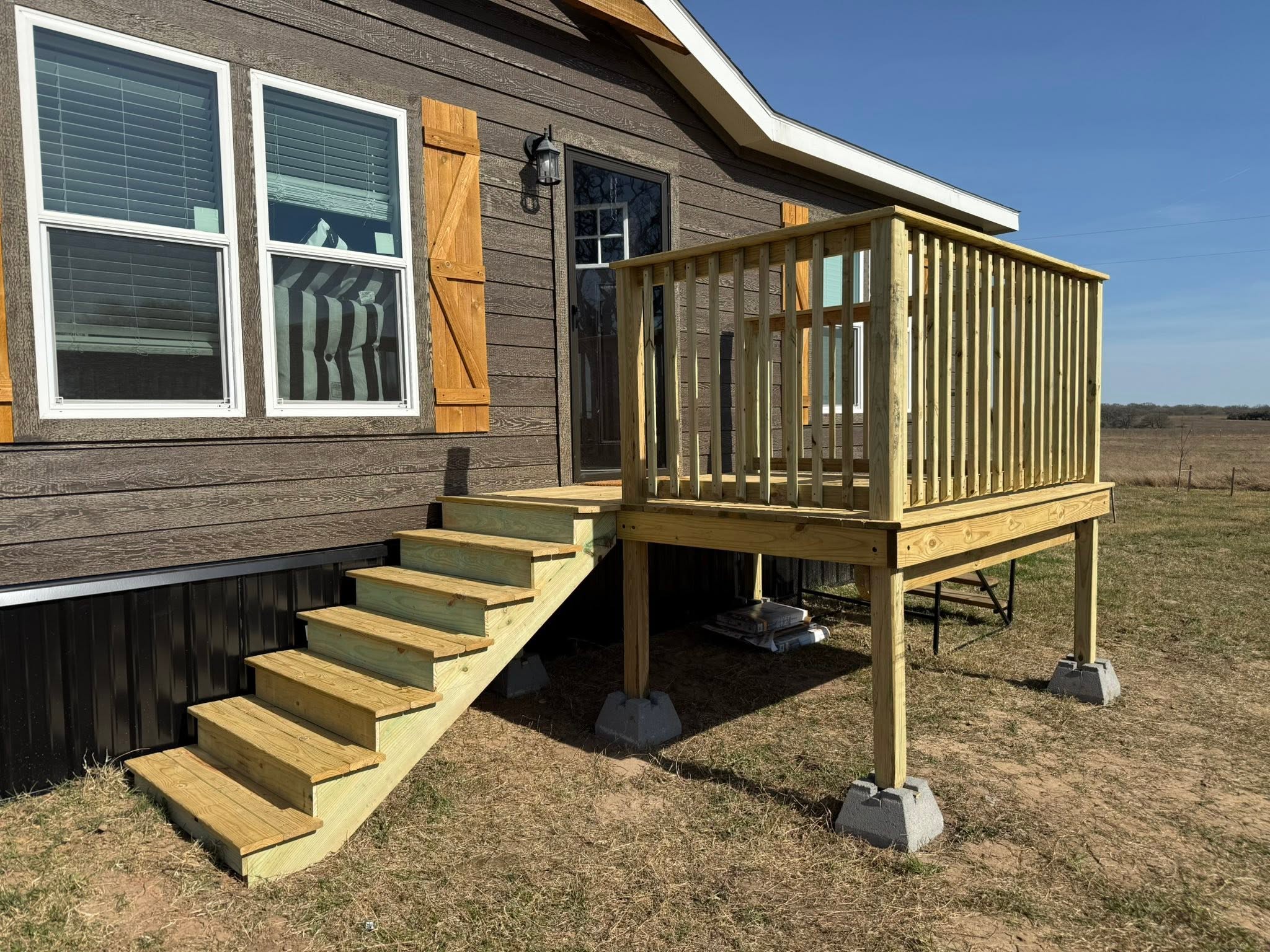Wood deck with railing and open stairs on a modular home