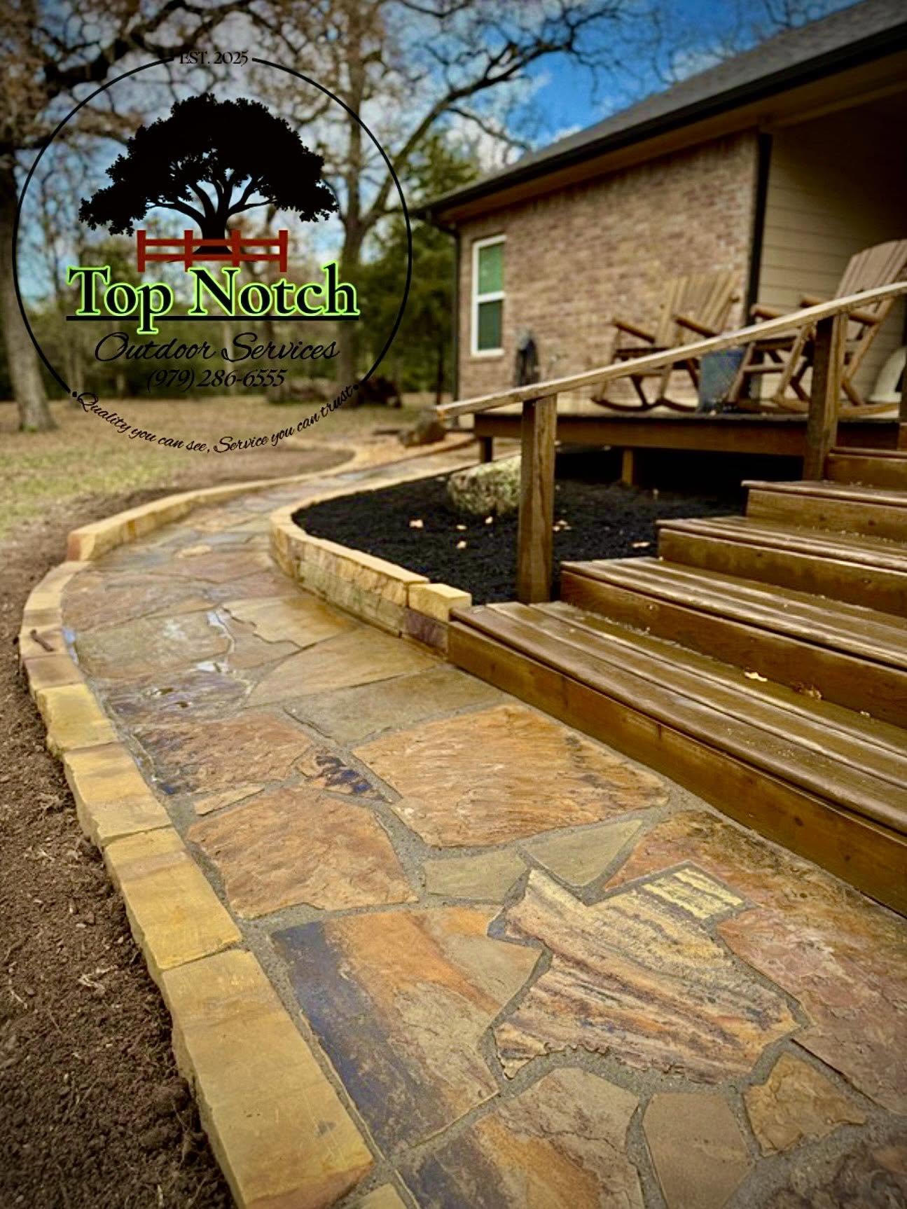 Curved flagstone walkway leading to a deck with rocking chairs